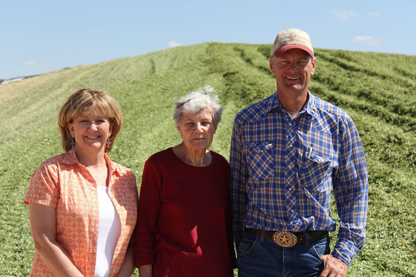 The Mellema family poses in front of the silage (chopped up corn plant) pile at their dairy.