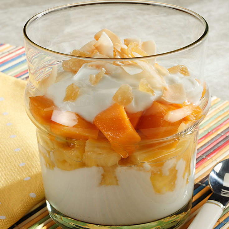 yogurt and tropical fruits layered in a glass dish